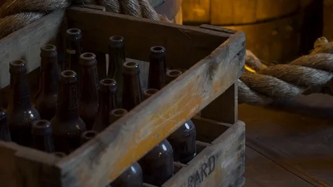 Slow push in over cargo rope and old bottles &amp; barrels from the speakeasy Stock Footage 104385711