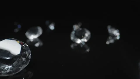 Slow push in on round classic diamond in dark black surface and background Stock Footage 225940962