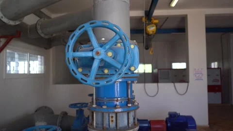 Slow Push-In Shot of Large Blue Industrial Valve Wheel in Modern Pumping Station Vídeos de archivo 334623377