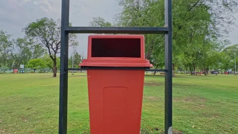 Slow Push In Toward Public Garbage Bin in Landscaped Urban Park Stock Footage 338426889
