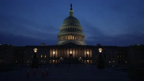 Slow push in to the US Capitol with lights and flags waving in Washington DC at Stock Footage 238954093