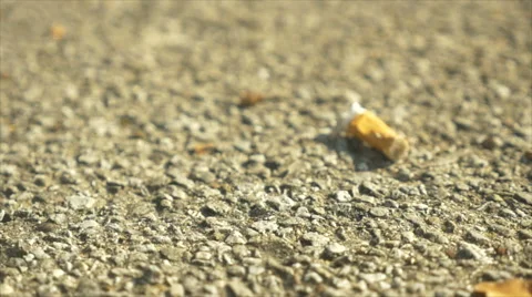 Slow Rack focus of Cigarette Butt on ground Stock Footage 42106268
