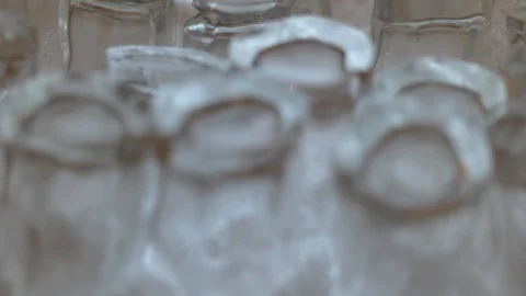 Slow rack focus ice shot glasses Stockbeeldmateriaal 125039059