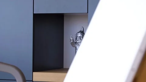 Slow revealing shot of a silver gnome ornament gesturing with its hands Stock Footage 250337447