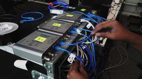 Slow revealing shot of a software engineers hands plugging cables into the 스톡 동영상 244787433