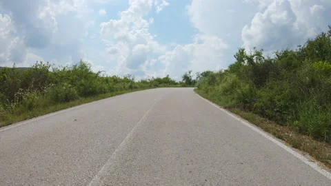 A slow ride in a car or motorcycle uphill on a winding mountain road POV Stock Footage 247264591