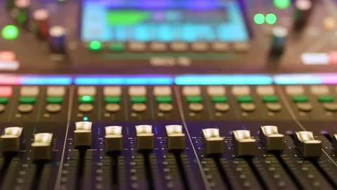 Slow right pan across a digital audio mixing console with faders, knobs and 스톡 동영상 328338649