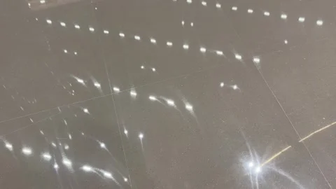 Slow rightward pan over a glossy marble floor reflecting ceiling lights Vídeos de archivo 331556331