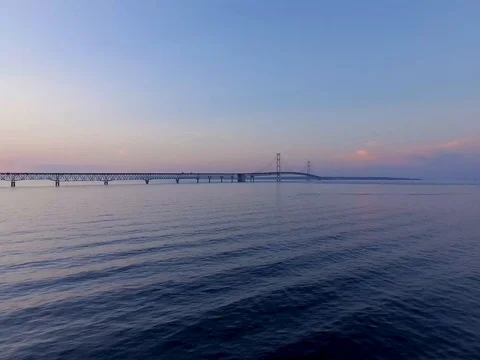 Slow rippling waves with sunset and Mackinac Bridge in the background Stock Footage 80893470