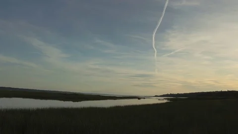 Slow rising tide with clouds and a few planes passing by. 動画素材 118301790