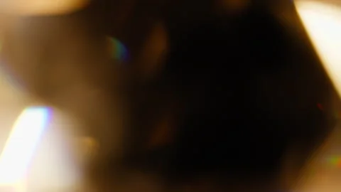 Slow romantic orange light leaks from a rotating glass prism Stock Footage 345514945