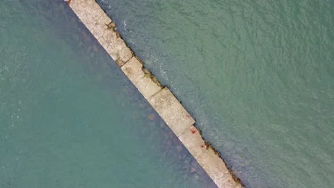 Slow rotating bird's eye view of sidewalk over water 스톡 동영상 208598028