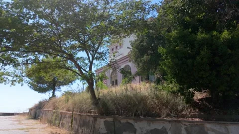 A slow rotating handheld pan shot of abandoned villa with a view from the sea 動画素材 345730139