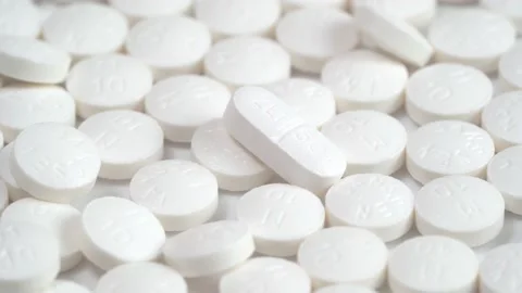 Slow rotation of a large group of white pills and one different pill Stock Footage 140290207