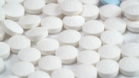 Slow rotation of a large group of white pills and one blue pill on the middle Stock Footage 140291379