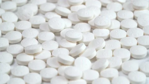Slow rotation of a large group of white pills on a white background Stock Footage 140318943