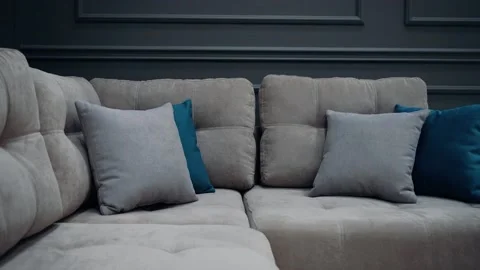 Slow shot of a gray couch with two gray and two blue pillows. 4k video Stock Footage 231508443