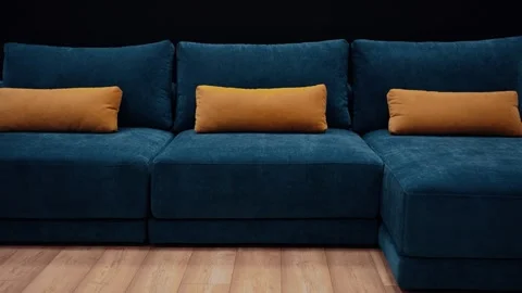 Slow shot in the office towards a dark blue couch with three long yellow pillows Stock Footage 233379429