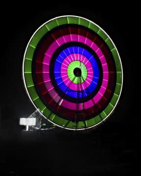 Slow shutter image of a rotating Giant Colorful Ferris wheel spinning at nigh Stock Photos