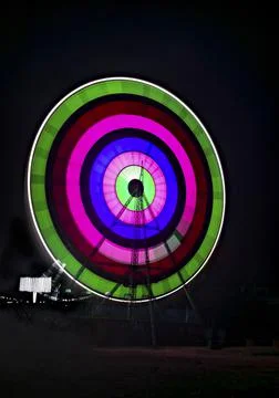 Slow shutter image of a rotating Giant Colorful Ferris wheel spinning at nigh Stock Photos