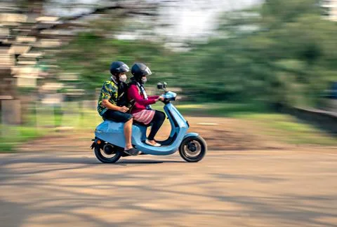 Slow shutter, Motion blur image of a couple wearing helmets for safety, ridin Stock Photos