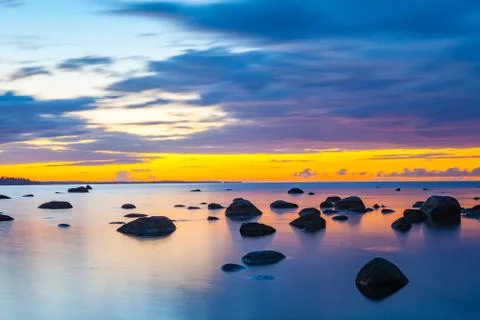 Slow shutter seascape view dark stones in beautiful sunset Stock Photos