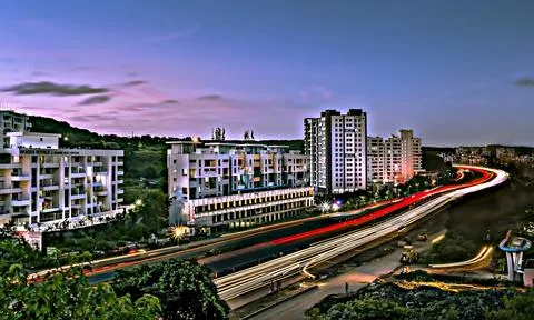Slow shutter speed image of beautiful sky , buildings and flowing traffic on  Stock Photos