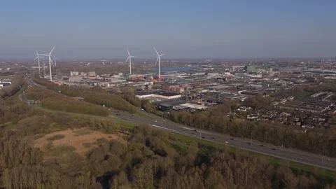 Slow side aerial approach to wind turbines and highway traffic Stock Footage 335651725