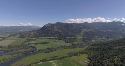 Slow side tracking shot of jagged mountains and miandering lakes - BC Farmlan Vídeo Stock 93420434