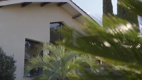 A slow, side-view shot revealing a spacious property with large bay windows and Stock Footage 336612892