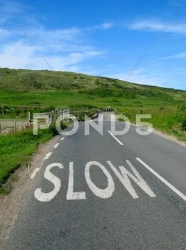 Slow sign on an english countryside road. Stock Photos