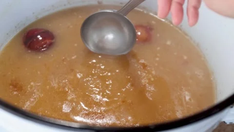 Slow-simmered bone broth in a cozy home kitchen: long, nourishing stock from Stock Footage 344031969
