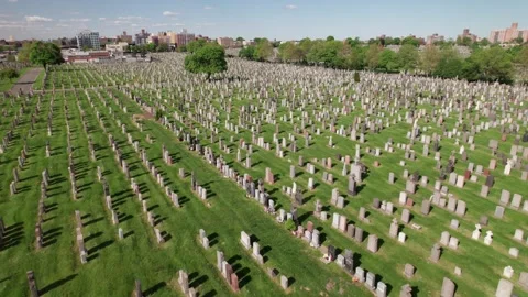 Slow smooth drone pull out shot over rows of graves in a huge garden Stock Footage 240911268