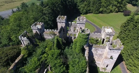 Slow Spin Drone Shot of Scottish Castle Ruins Surrounded by Small Forest 스톡 동영상 97527486