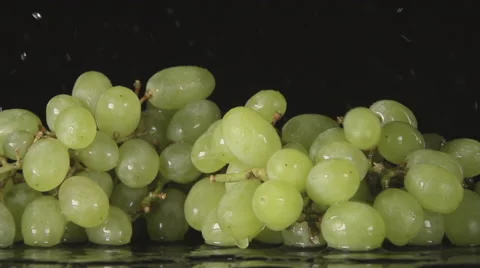SLOW: A splash - A green grape bunch falls on a black background Видео 64209787