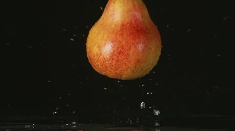 SLOW: A splash - A red pear falls on a black background Vídeo Stock 64209693