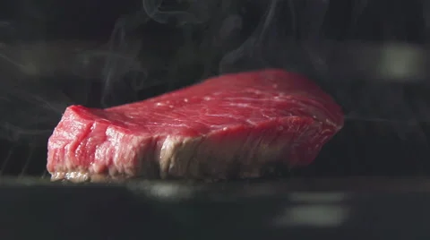 SLOW: Steak of meat is cooking on a grill Stock Footage