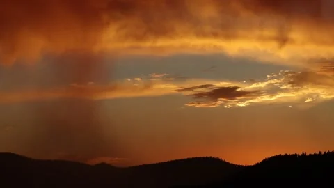 Slow Sunset Pan with Mountain Range and Orange Sky Stock Footage 136147173