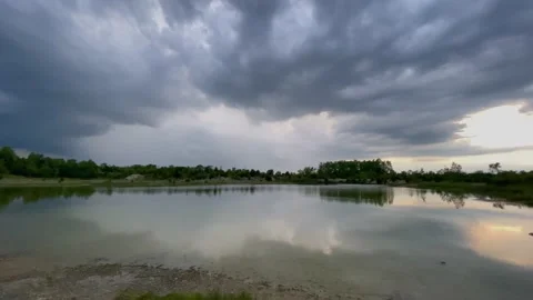 Slow super wide angle shot of storm clouds in big summer sky over reflective Stock Footage 156504236
