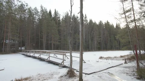 Slow tacking shot over a snowy frozen wooden bridge Stock Footage 146278018