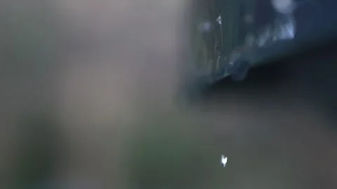 Slow tempo water droplets fall from the roof's edge, reflecting a rainy day.. Stock Footage 254263169