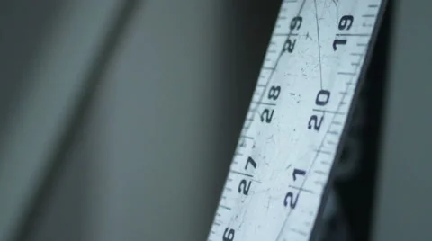 Slow Tilt-Down Shot of Vertical Metal Ruler 库存影片 40745952