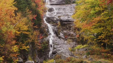 Slow tilt up pan of a stream of water running down a cliff 4K UHD Stock Footage 47573257