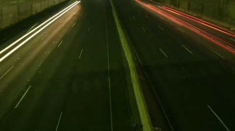 A slow tilt up reveals traffic move at light speed along a Stock Footage