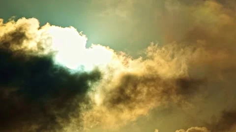 Slow timelapse of dramatic sunlit clouds shifting across the sky, revealing Stock Footage 326281788