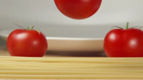 SLOW: A tomato falls on a spaghetti on a table Stock Footage 62681825