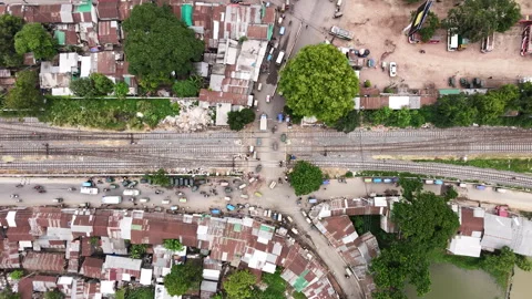 Slow Top-Down Aerial Descent Over Busy Railway Level Crossing in Ishwardi Stock Footage 335880212