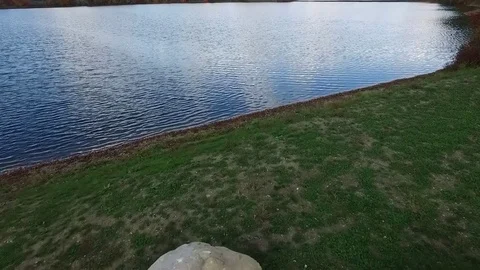 Slow tracking climbing shot over water nondescript house on point fall color Stock-Footage 70998658