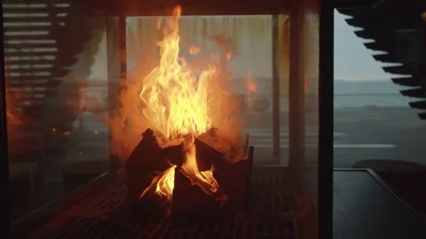 Slow tracking close up shot around a roaring fire in the middle of an empty room Stock Footage 146289370