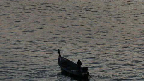 Slow tracking forward Silhouette of a man on a longtail fishing boat Stock Footage 232298078